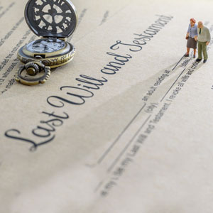 Miniature people signing a last will and testament on paper. - Gomez Law PLLC